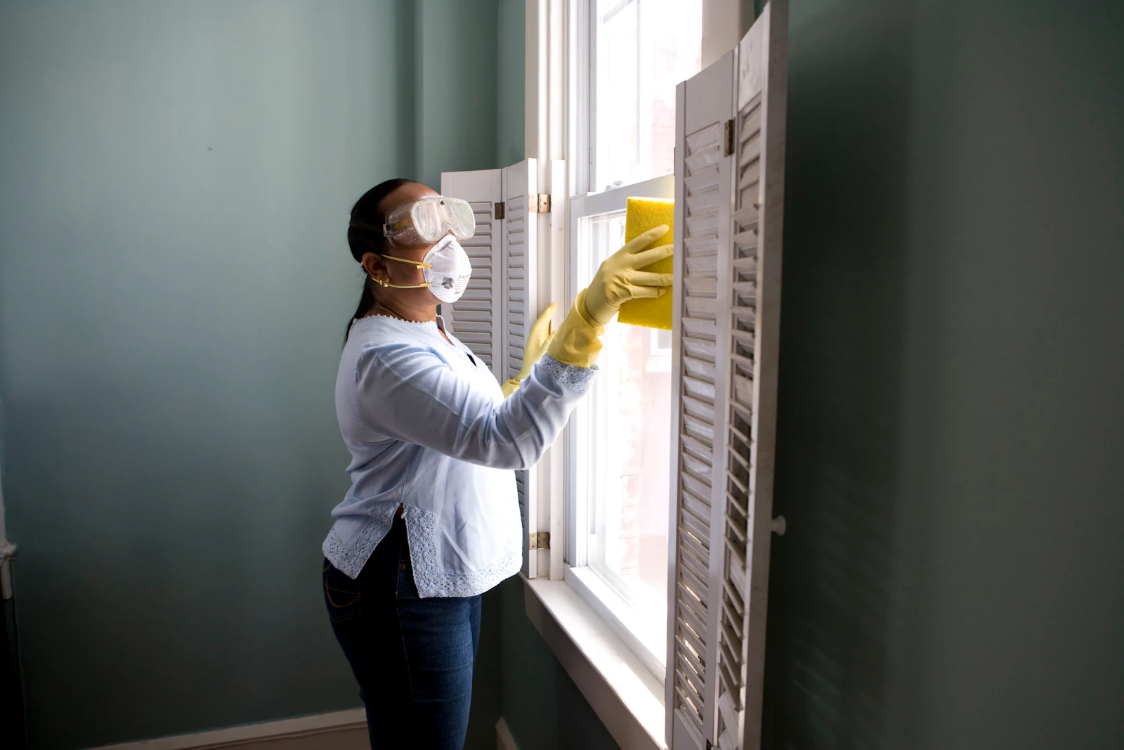 Homeowner cleaning a window in spring